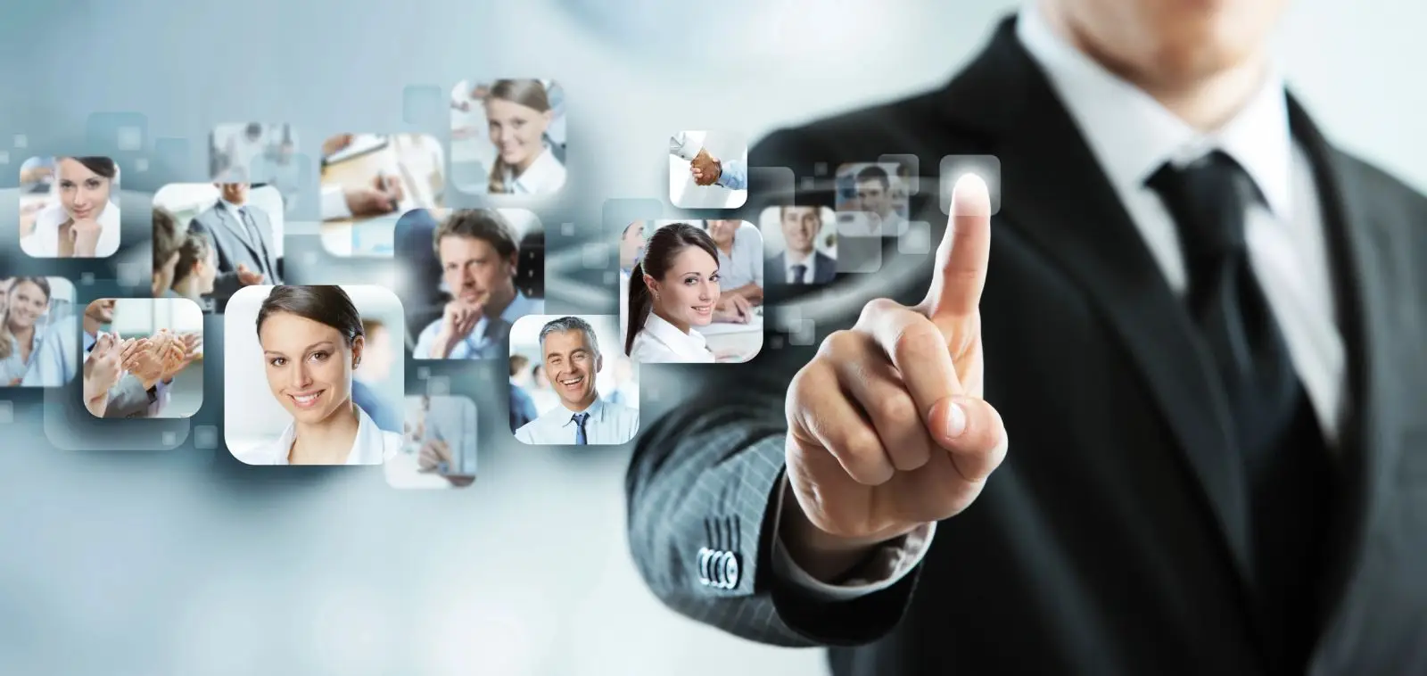 Business professional in a suit interacting with a virtual interface displaying diverse team members’ portraits, symbolizing networking, digital collaboration, and modern corporate communication.